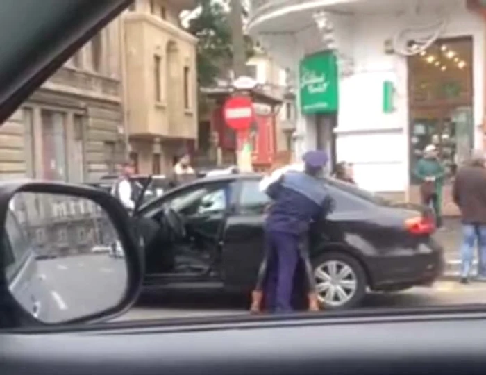 Femeia este scoasă din maşină şi încătuşată de reprezentanţii poliţieifoto: captură video