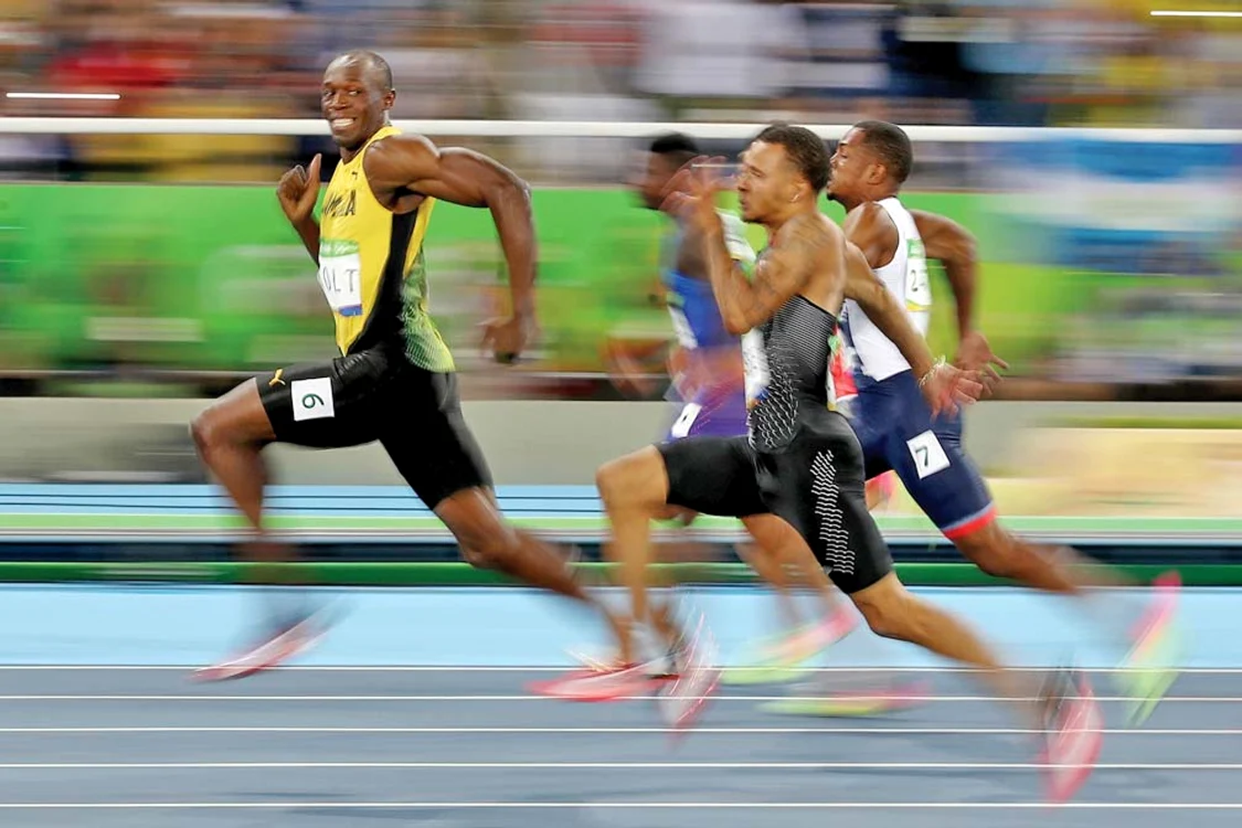 Usain Bolt a avut puterea de a zâmbi fotoreporterilor spre finalul cursei