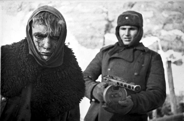 Soldat sovietic înarmat cu un pistol-mitralieră PPŞ-41 escortează un prizonier german după Bătălia de la Stalingrad (© Bundesarchiv, Bild 183-E0406-0022-011 / CC-BY-SA 3.0)