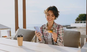 Tânără la terasa în vacanța cu un card și un telefon FOTO Shutterstock 