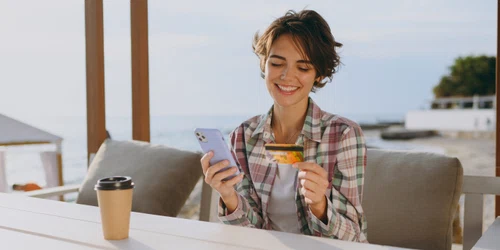 Tânără la terasa în vacanța cu un card și un telefon FOTO Shutterstock 