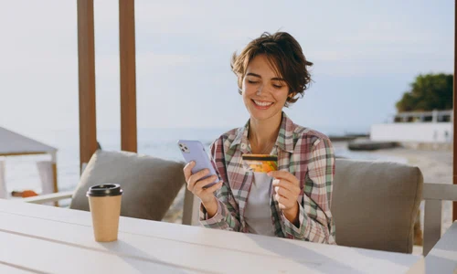 Tânără la terasa în vacanța cu un card și un telefon FOTO Shutterstock 