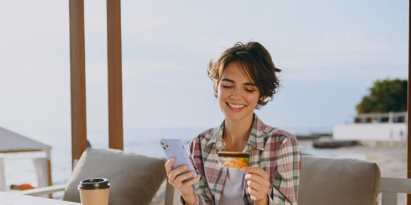 Tânără la terasa în vacanța cu un card și un telefon FOTO Shutterstock 
