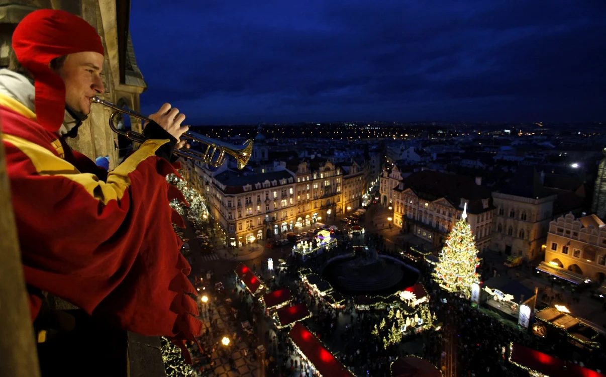 Un bărbat suflă în trompetă în turnul din piaţa centrală a oraşului Praga la ceremonia de aprindere a luminilor bradului FOTO Reuters