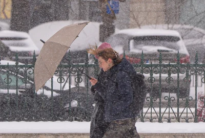 O tânără se adapostește sub o umbrela în timpul unei ninsori, in Bucuresti FOTO Mediafax - meteo - vremea- ninsoare - frig