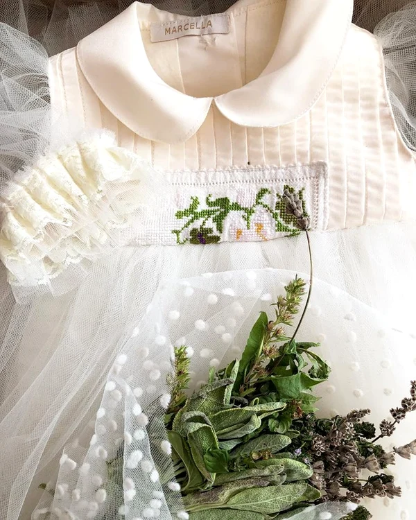 Rochia de botez a fiicei Laurei Cosoi are un model floral cusut de mână