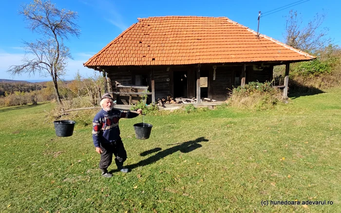 Traian cară zilnic gălețile cu apă, cu cobilița. Foto: Daniel Guță. ADEVĂRUL