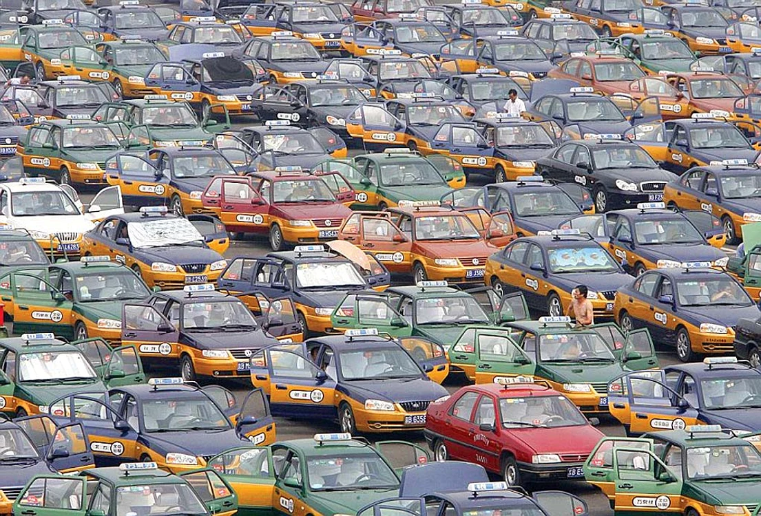 Sute de taxiuri stau  aliniate în parcarea  aeroportului