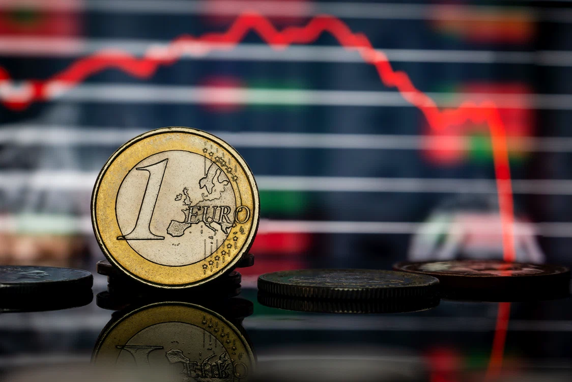 Moneda de 1 euro pe fondul unui grafic care indică scădere abruptă a economiei globale