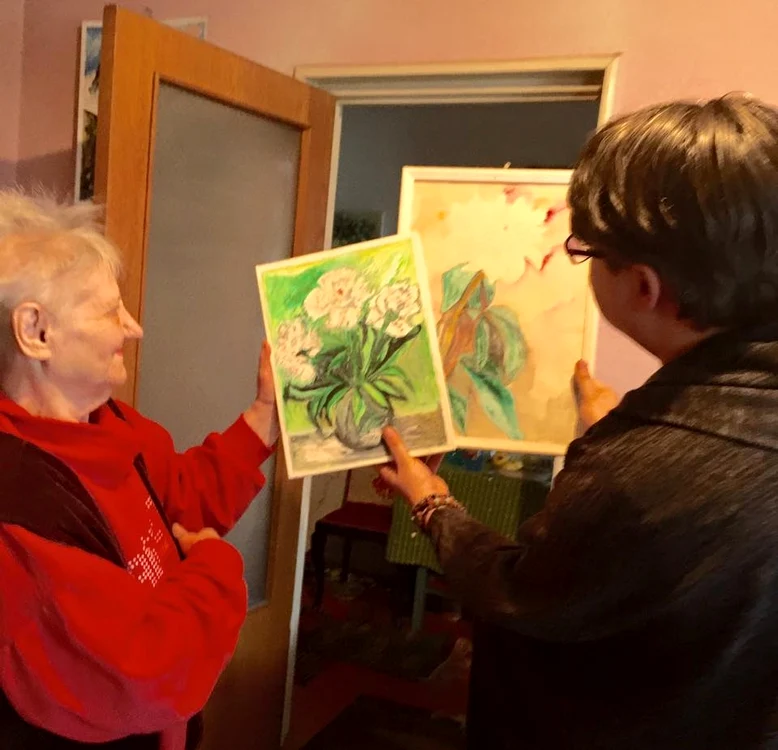 Fuego (39 de ani) și Elisabeta Preda (86 de ani), alături de câteva dintre lucrările pictoriței