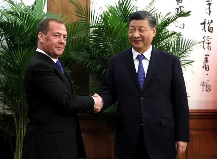 Medvedev (stânga) dând mâna cu Xi în cadrul deplasării de la Beijing FOTO EPA-EFE