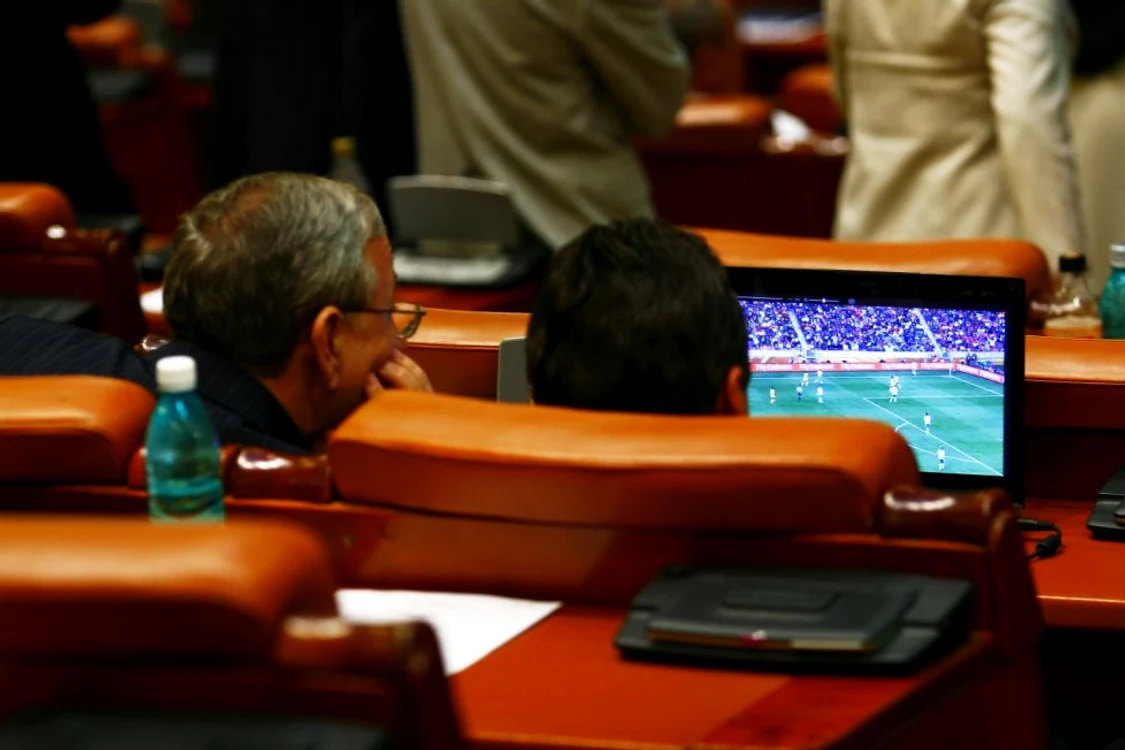 
    Doi deputați au fost surprinși când vizionau în banca Parlamentului un meci de fotbal (foto: adevarul.ro)  