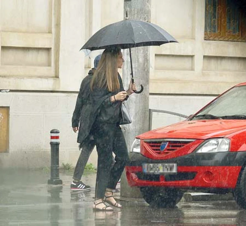 
    Îmbrăcată complet în negru,  Romaniţa Iovan a mers  la mormântul lui Iovan  pe o ploaie torenţială (Fotografii: Alex Muscaliu)  