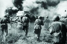 Tancuri T-34, urmate de infanteria sovietică, avansează pe câmpul de bătălie (© wikipedia.org)