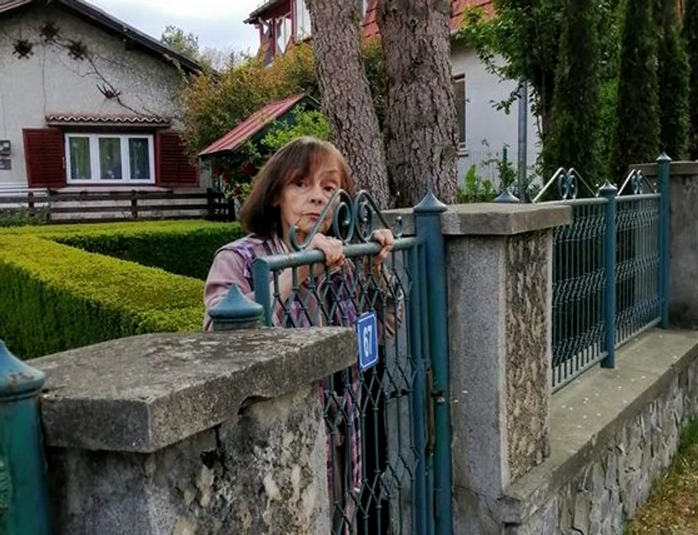 Marina Voica, lipită de gard, așteptând să schimbe o vorbă cu cinevafoto: Facebook