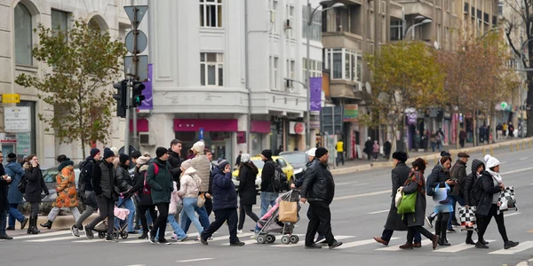 Oameni care traverseaza strada pe trecerea de pietoni in Bucuresti - populatie FOTO Shutterstock 