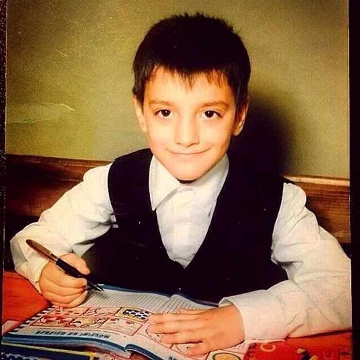 Liviu Teodorescu, în copilărie, la școală, cu manualul în față și stiloul în mână