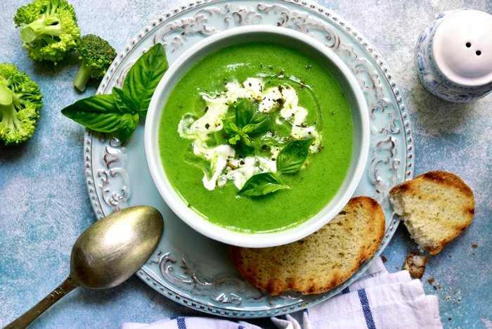 Supă-crem verde de broccoli cu smântână și crutoane, într-un bol