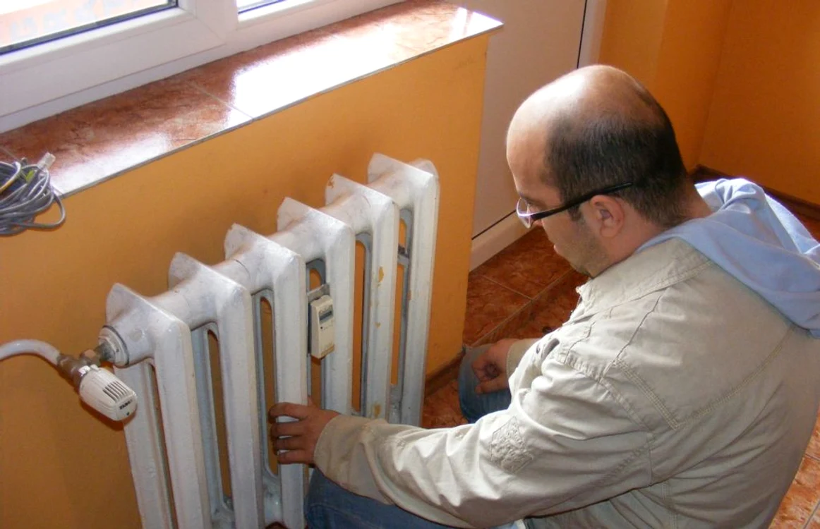 Un locatar verifică repartitorul de costuri la căldură