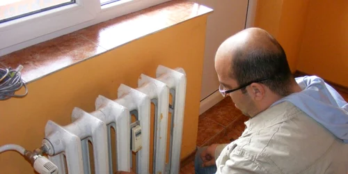 Un locatar verifică repartitorul de costuri la căldură