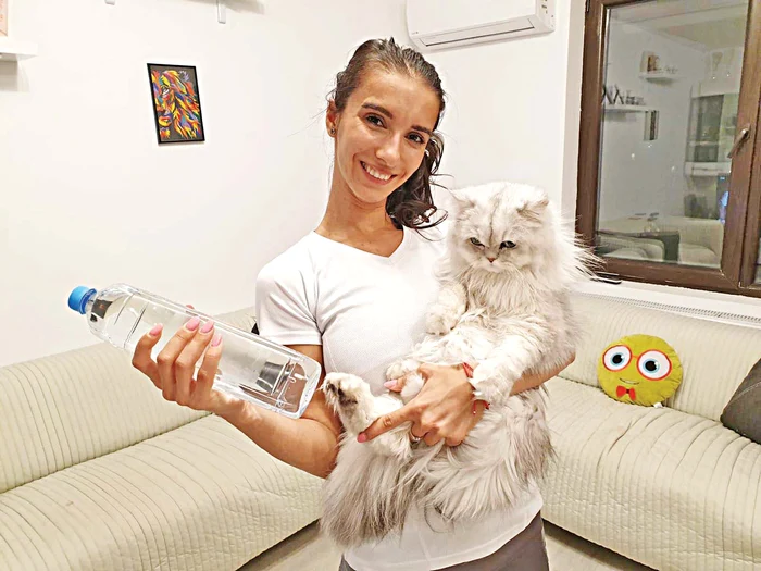 Denisa are două „gantere”: sticla de apă și pisica