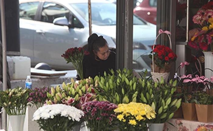 O florăreasă îşi serveşte clienţii aşa cum o făcea înainte de pandemie