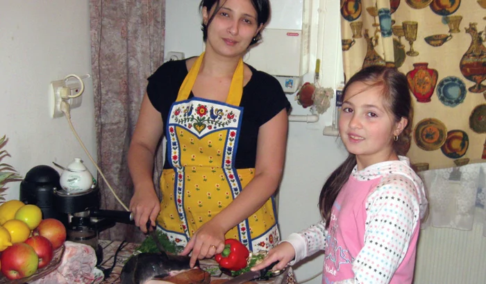 Diana Maroleanu şi fetiţa sa Iulia pregătesc peşte pentru masa de Revelion, pentru a avea parte de un an mai bun