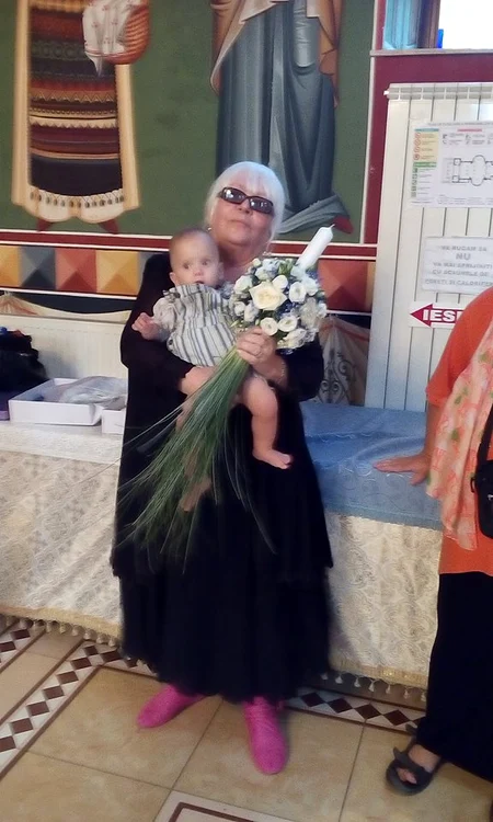 Micuțul, în brațele nașei