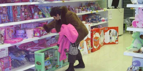 O băcăuancă se uită cu atenţie la jucăriile din raft