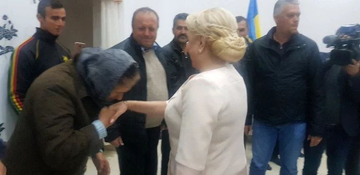 Momentul în care o femeie îi sărută mâna Vioricăi Dăncilă. FOTO: Oana Şlemco