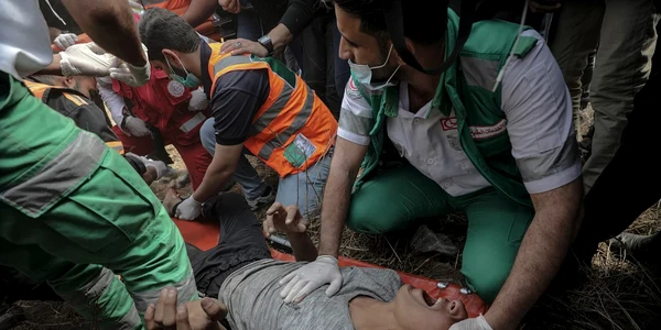 Medici palestinieni încearcă să ajute un tânăr rănit în timpul ciocnirilor după protestele de lângă graniţa cu Israel în estul oraşului Gaza FOTO EPA-EFE / Mohhamed Saber