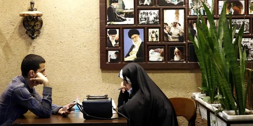 Doi tineri sa intalnesc intr-o cafenea din Teheran ornata cu portretele ghidului suprem FOTO EPA-EFE