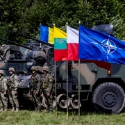 Soldați polonezi și români stau lângă vehicule militare cu steagul NATO Foto AFP jpg