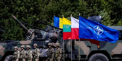 Soldați polonezi și români stau lângă vehicule militare cu steagul NATO Foto AFP jpg