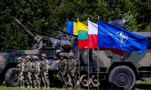 Soldați polonezi și români stau lângă vehicule militare cu steagul NATO Foto AFP jpg
