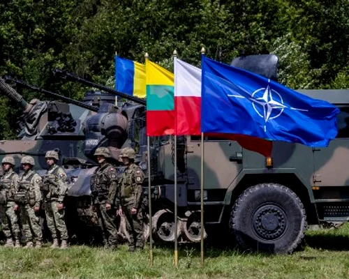 Soldați polonezi și români stau lângă vehicule militare cu steagul NATO Foto AFP jpg