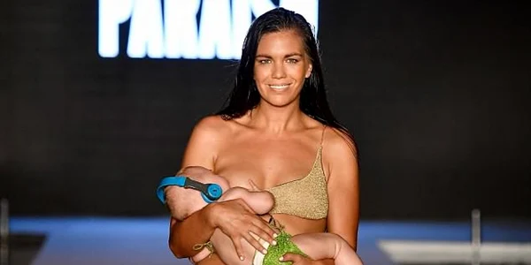 model alaptand copilul in timpul unei prezentari