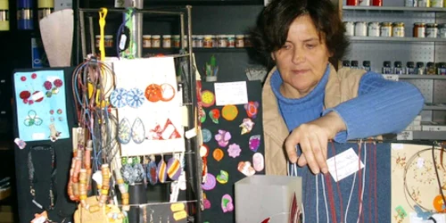 Cristina Marciuc se ocupă de vânzarea colierelor şi cerceilor din fimo la Fondul Plastic