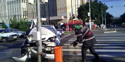 Maşina a luat foc după impactul cu stâlpul de susţinere a semaforului