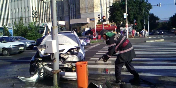 Maşina a luat foc după impactul cu stâlpul de susţinere a semaforului