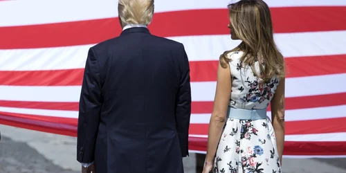 Preşedintele american Donald Trump şi soţia sa Melania trec pe lângă steagul SUA în timp ce participă la parada militară tradiţională parte a sărbătorilor de Ziua Bastiliei la Paris Franţa FOTO EPA / Ian Langsdon