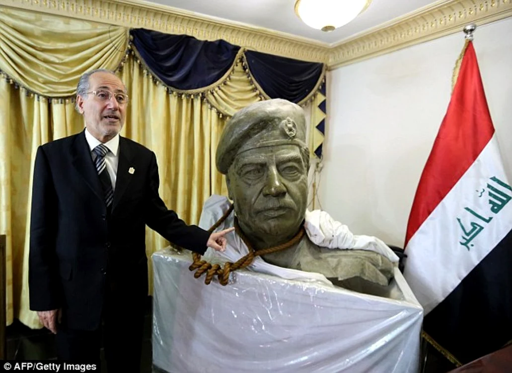 Mowaffak al-Rubaie, fost consilier de securitate în Irak, ţine funia în jurul unui bust al fostului dictator. FOTOGRAFII via „Daily Mail”