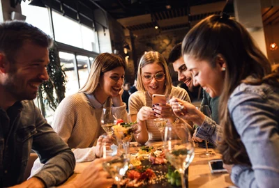 Restaurant - prieteni la masa - mancare - telefon - socializare FOTO Shutterstock 
