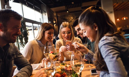 Restaurant - prieteni la masa - mancare - telefon - socializare FOTO Shutterstock 