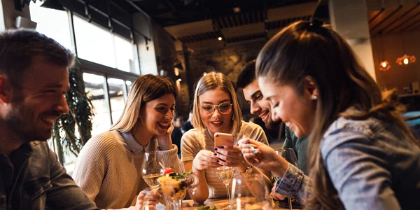 Restaurant - prieteni la masa - mancare - telefon - socializare FOTO Shutterstock 