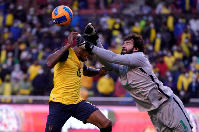 Alisson boxează un balon de lângă un jucător advers (Foto: EPA-EFE)