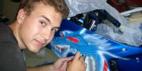 Unul dintre pictorii atelierului îşi prezintă ultima lucrare