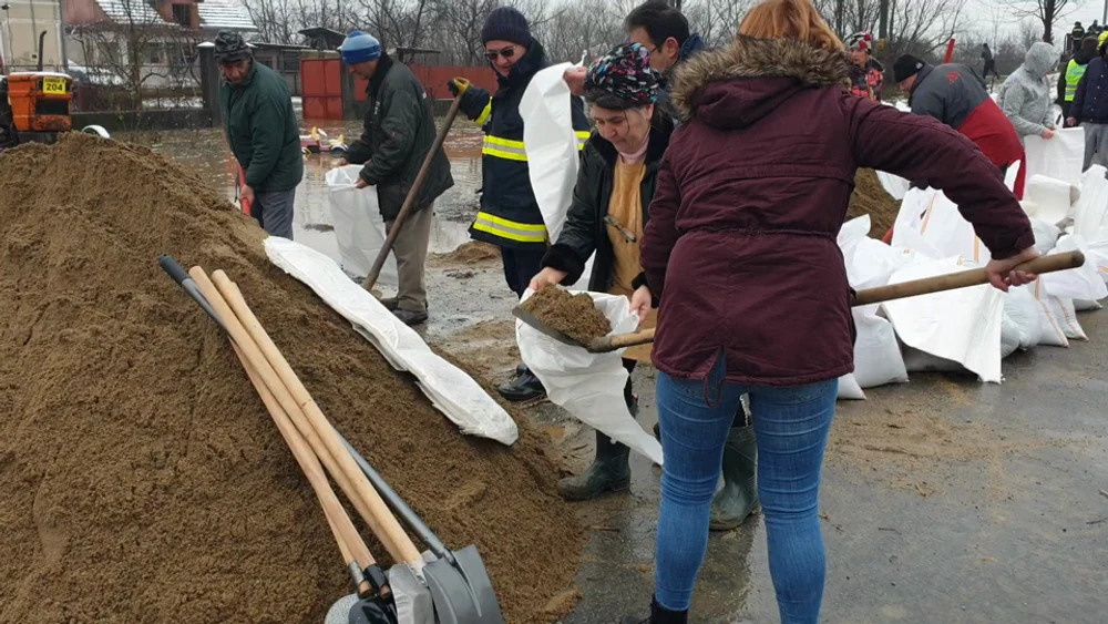 Lecția de implicare a unor femei din Timiș. Au pus mâna pe lopeți și au cărat saci de nisip pentru consolidarea unui dig VIDEO