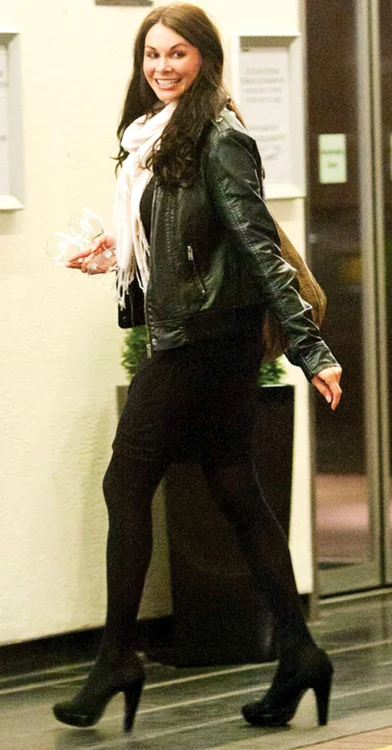 Emma se duce cu două pahare de şampanie la un client