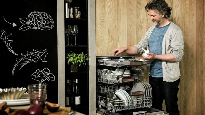 Bărbat în bucătărie punând detergent într-o mașină de spălat vase slim Foto Expert Reviews jpg